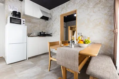 a kitchen with a table and a white refrigerator at Urban Stay Oshiage in Tokyo