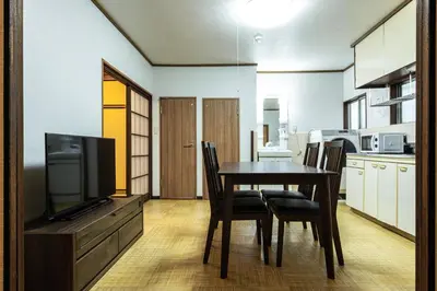 a dining room with a table with chairs and a television at Urban Stay Aoto in Tokyo