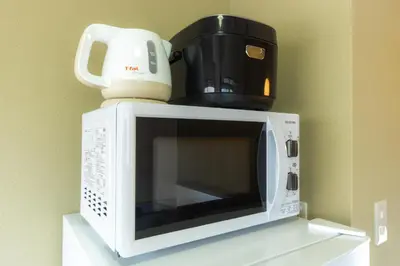 a microwave with a coffee maker on top of it at Urban Stay Aoto in Tokyo