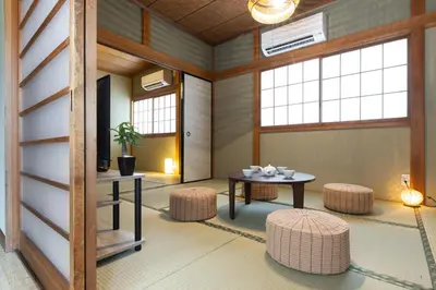 a room with a table and stools and windows at Urban Stay Aoto in Tokyo