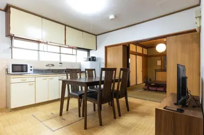 a kitchen with a table and chairs and a television at Urban Stay Aoto in Tokyo