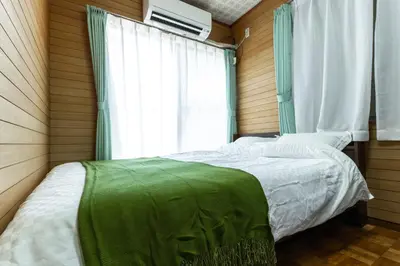 a bedroom with two beds and a window at Urban Stay Aoto in Tokyo