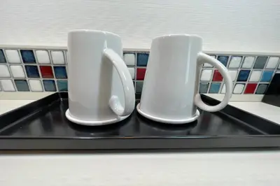 two white coffee mugs sitting on a tray at Asta Hotel in Tokyo