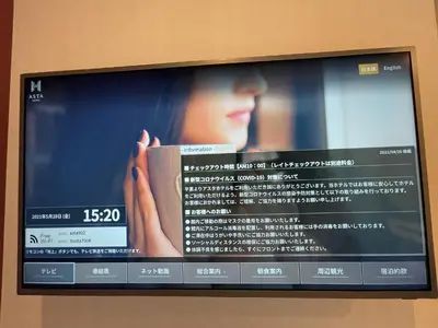 a television screen with a woman holding a book at Asta Hotel in Tokyo