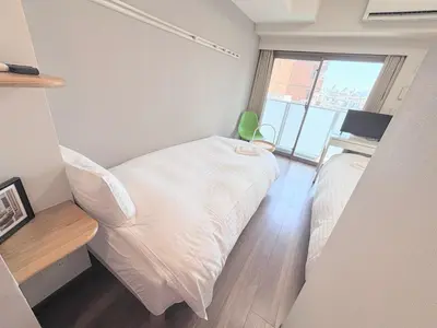 a small room with a bed and a window at Otsuka No 4 Mansion in Tokyo