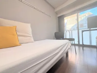 a white bed in a room with a window at Otsuka No 4 Mansion in Tokyo
