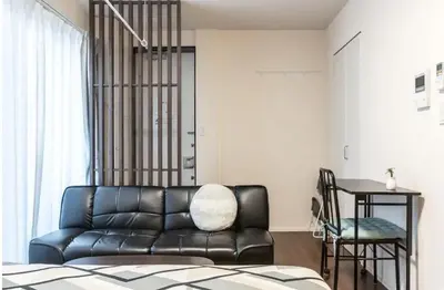 a living room with a black leather couch and a table at T-BASE - Vacation STAY 21950v in Tokyo
