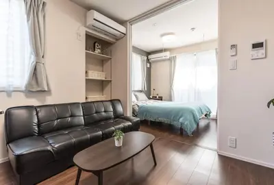 a living room with a leather couch and a bed at T-BASE - Vacation STAY 21952v in Tokyo