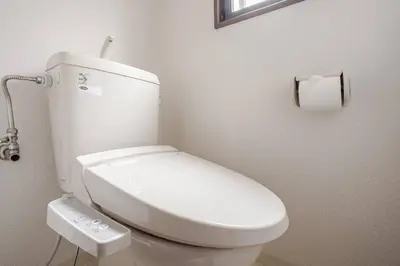 a white toilet in a bathroom with a roll of toilet paper at Papa201 in Tokyo
