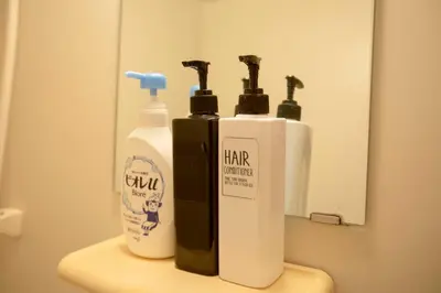 two bottles of hair products sitting on top of a sink at Papa201 in Tokyo
