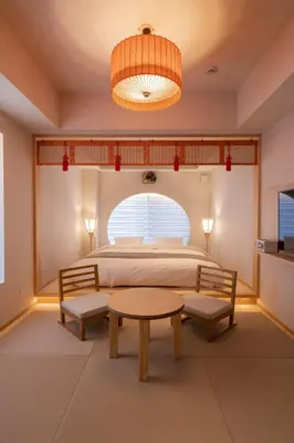 a bedroom with a bed and a table and a window at moire HOTEL YOSHIWARA in Tokyo