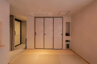 an empty hallway with pivot doors in a house at moire HOTEL YOSHIWARA in Tokyo
