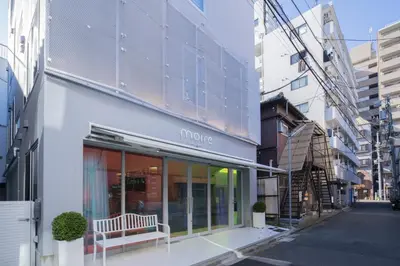 a white building with a bench outside of it at moire HOTEL YOSHIWARA in Tokyo