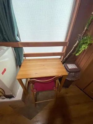 a wooden table sitting in front of a window at 54Journey \u6771\u4eac\u5927\u624b\u753a\u30db\u30b9\u30c6\u30eb in Tokyo