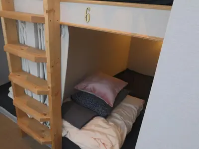 a bunk bed with a couch on the bottom bunk at 54Journey \u6771\u4eac\u5927\u624b\u753a\u30db\u30b9\u30c6\u30eb in Tokyo
