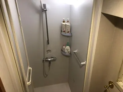 a small bathroom with a shower and a toilet at 54Journey \u6771\u4eac\u5927\u624b\u753a\u30db\u30b9\u30c6\u30eb in Tokyo