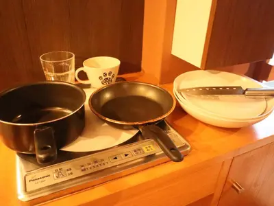 a counter with two frying pans on a scale at 54Journey \u6771\u4eac\u5927\u624b\u753a\u30db\u30b9\u30c6\u30eb in Tokyo