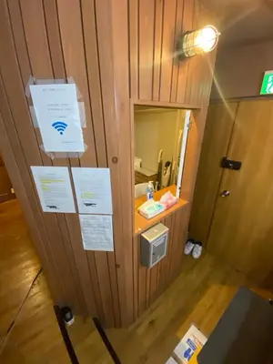 a room with a wooden wall with signs on it at 54Journey \u6771\u4eac\u5927\u624b\u753a\u30db\u30b9\u30c6\u30eb in Tokyo