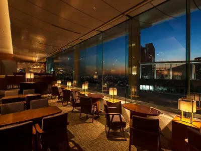 a restaurant with tables and chairs and a view of the city at Odakyu Hotel Century Southern Tower in Tokyo