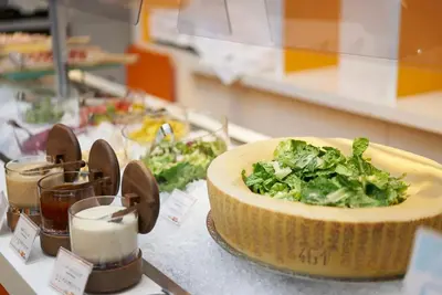 a table with a bowl of greens on a counter at Oriental Hotel Tokyo Bay in Urayasu