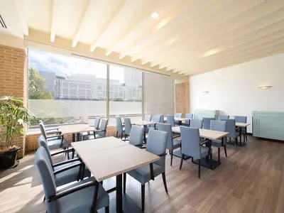 a restaurant with tables and chairs and a large window at Oriental Hotel Tokyo Bay in Urayasu