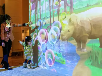 a woman and a child looking at a rhino exhibit at Oriental Hotel Tokyo Bay in Urayasu