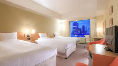 a hotel room with two beds and a television at Tokyo Dome Hotel in Tokyo