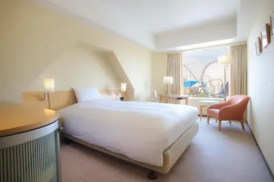 a hotel room with a large bed and a roller coaster at Tokyo Dome Hotel in Tokyo