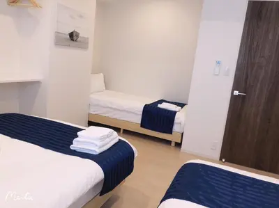 a small room with two beds and a closet at Hotel Emir in Tokyo