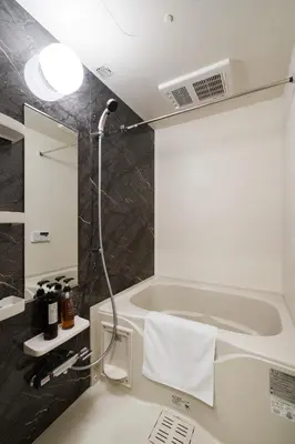 a bathroom with a shower and a bath tub at Hotel Emir in Tokyo