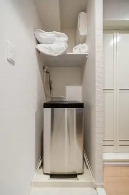 a room with a towel shelf and a glass container at Hotel Emir in Tokyo