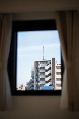 a view of a tall building from a window at Hotel Emir in Tokyo