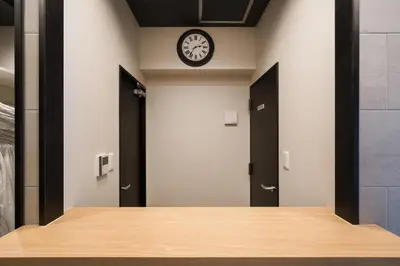 a hallway with doors and a clock on the wall at Hotel Emir in Tokyo