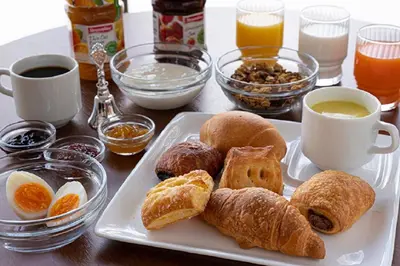 a table with a plate of pastries and cups of coffee at R&B HOTEL UENO HIROKOJI - Vacation STAY 13873v in Tokyo