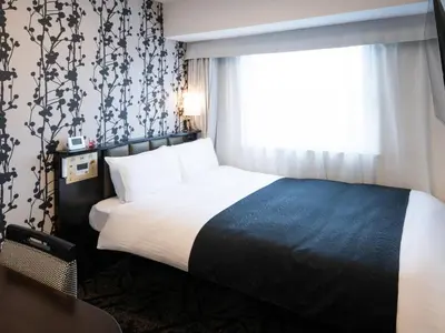 a hotel room with a bed and a window at APA Hotel Ueno Ekimae in Tokyo