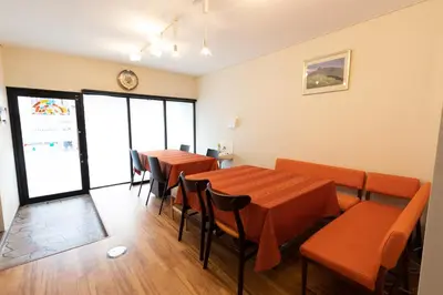 a dining room with tables and chairs and a clock at Annekaffeekanne in Tokyo