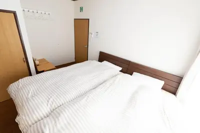 a bedroom with two beds with white sheets at Annekaffeekanne in Tokyo