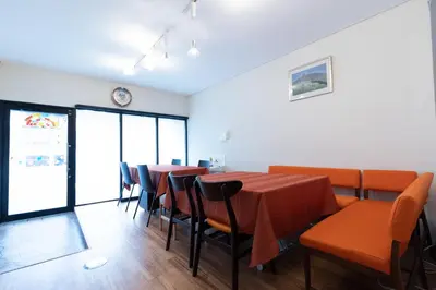 a dining room with orange tables and chairs at Annekaffeekanne in Tokyo