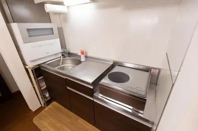a small kitchen with a sink and a microwave at Annekaffeekanne in Tokyo