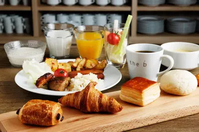 a table with a plate of breakfast foods and coffee at the b ginza in Tokyo