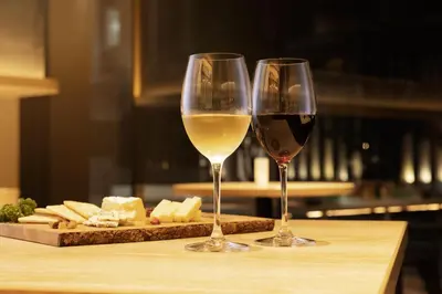 two glasses of wine and cheese on a cutting board at the b ginza in Tokyo