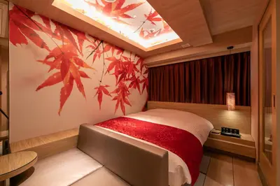 a bedroom with a bed with red leaves on the wall at Hotel Karuta -Love hotel in Tokyo