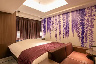 a bedroom with a bed and a purple wall at Hotel Karuta -Love hotel in Tokyo