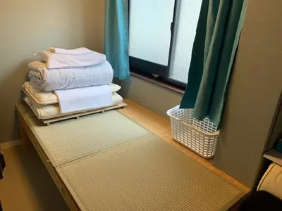 a room with a pile of towels and a window at Jing House akihabara Ryokan - Vacation STAY 30887v in Tokyo