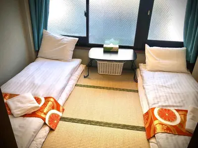 two twin beds in a room with a window at Jing House akihabara Ryokan - Vacation STAY 11566v in Tokyo