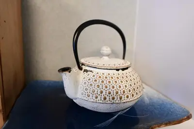 a white tea kettle sitting on a blue table at Jing House akihabara Ryokan - Vacation STAY 11566v in Tokyo