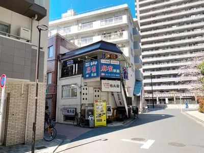 a building with a gas station in front of a building at SKYE HOME in Tokyo