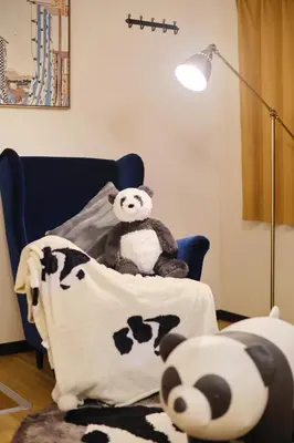 a teddy bear sitting on a bed with a blanket at TORA HOTEL Tokyo Ueno \u5bc5\u30db\u30c6\u30eb \u4e0a\u91ce A in Tokyo