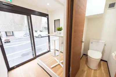 a bathroom with a toilet and a view of a street at TORA HOTEL Tokyo Ueno \u5bc5\u30db\u30c6\u30eb \u4e0a\u91ce A in Tokyo