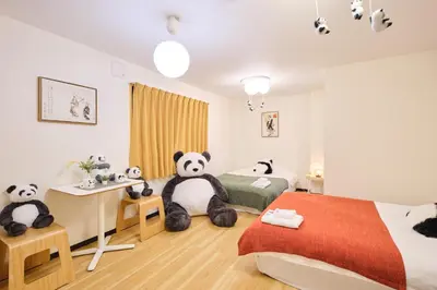 a bedroom with two panda bears sitting on the floor at TORA HOTEL Tokyo Ueno \u5bc5\u30db\u30c6\u30eb \u4e0a\u91ce A in Tokyo